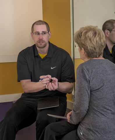 ACSM Certified Health Fitness Specialist, Timothy Thew consulting with personal training client on the best approach to achieve her fitness goals. 